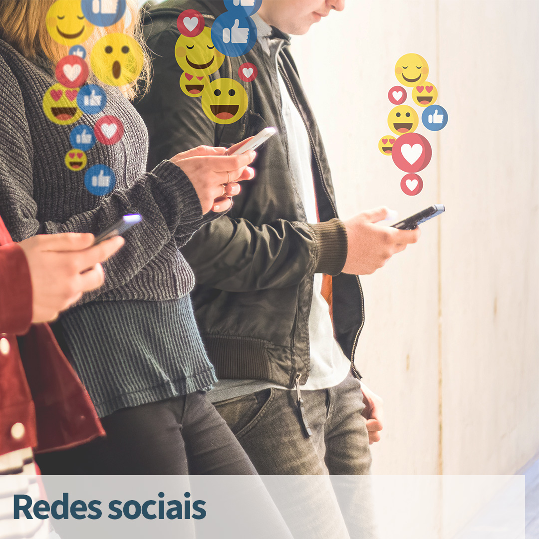 Conceito de rede social. Ícones de curtir, amar, surpreender e sorrir aparecem na tela do smartphone. Jovens viciados em aplicativos de redes sociais. Pessoas não reconhecíveis.