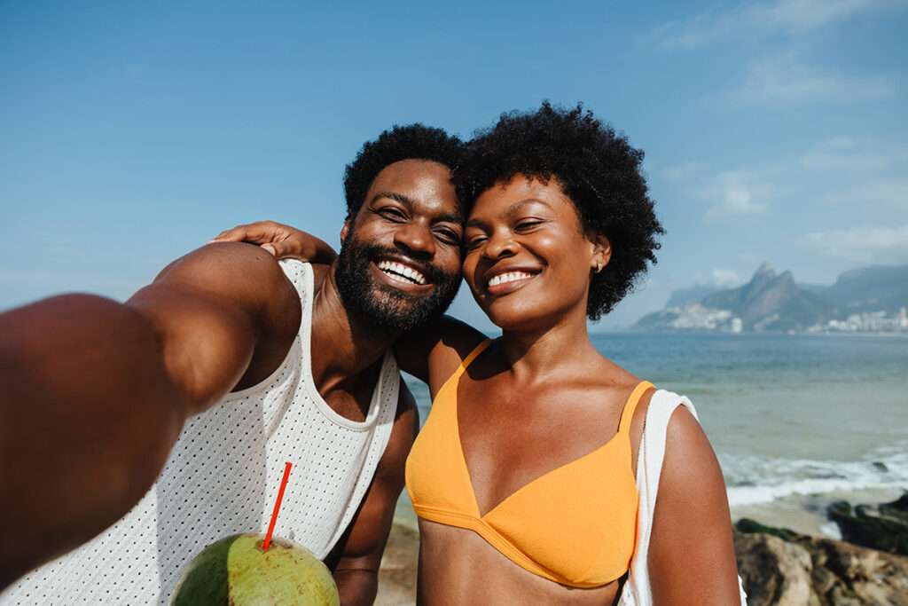 Pais felizes tirando uma selfie na Praia de Ipanema durante as férias